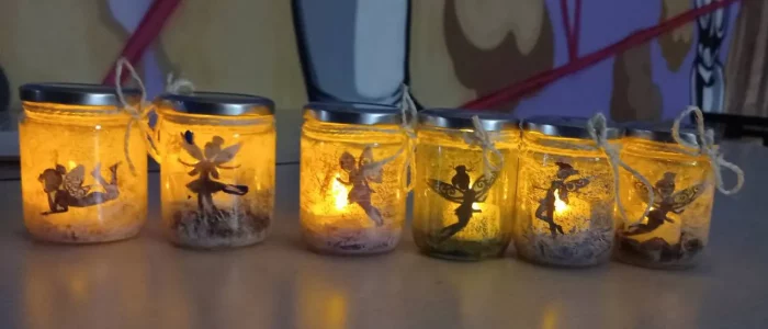 Animation de rue, 6 pots en verres décorés avec des bougies allumées dedans
