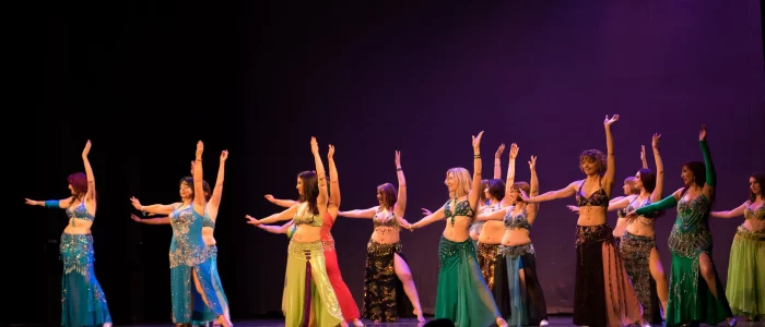 Danse orientale, groupe de femmes dansant en robe dans une salle de spectacle