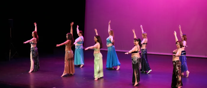 Danse orientale, groupe de femmes dansant en robe dans une salle de spectacle